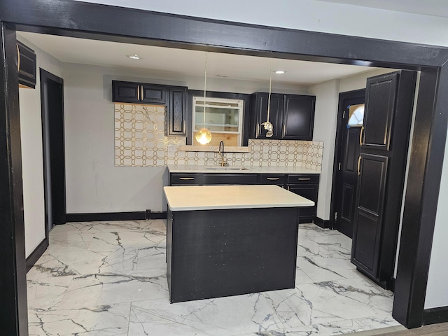 kitchen with decorative backsplash, decorative light fixtures, a kitchen island, and sink