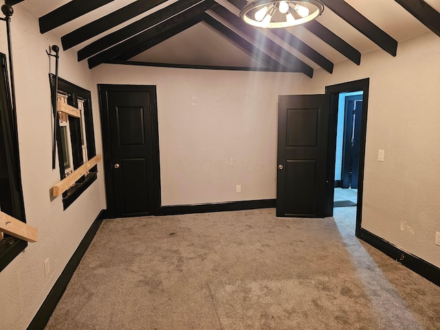 empty room with light carpet and lofted ceiling with beams