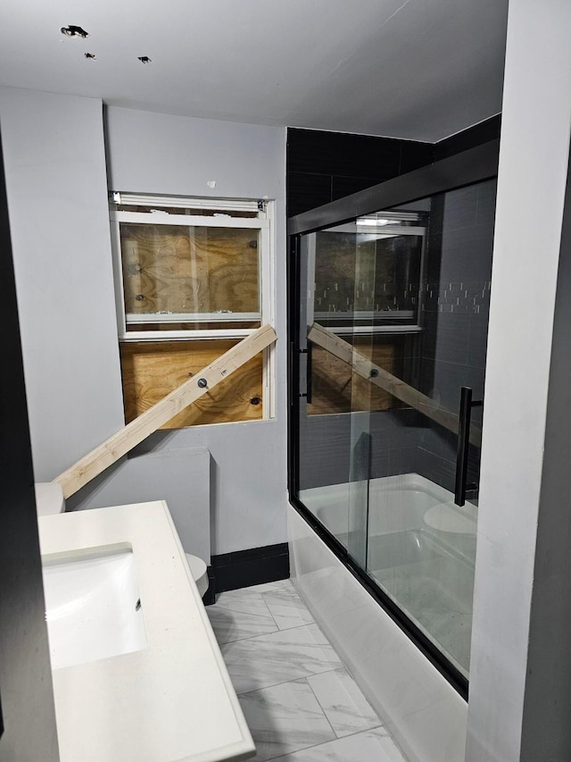 full bathroom featuring vanity, toilet, and bath / shower combo with glass door