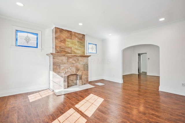 unfurnished living room with ornamental molding, wood-type flooring, and a tile fireplace