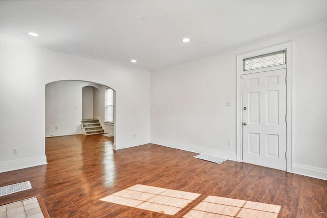 entryway with dark hardwood / wood-style floors and crown molding