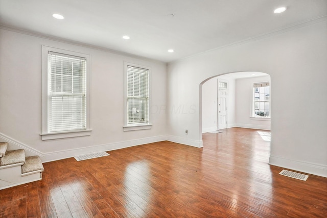 empty room with crown molding and wood-type flooring