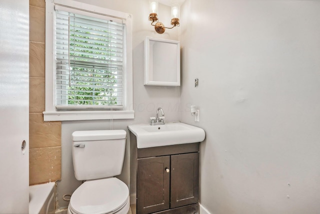 bathroom featuring toilet, vanity, and a bathing tub