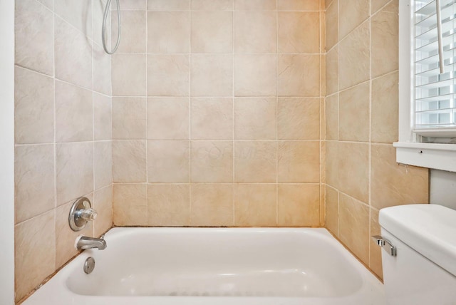 bathroom featuring toilet and tiled shower / bath combo