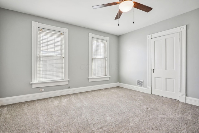 unfurnished room with carpet floors, plenty of natural light, and ceiling fan