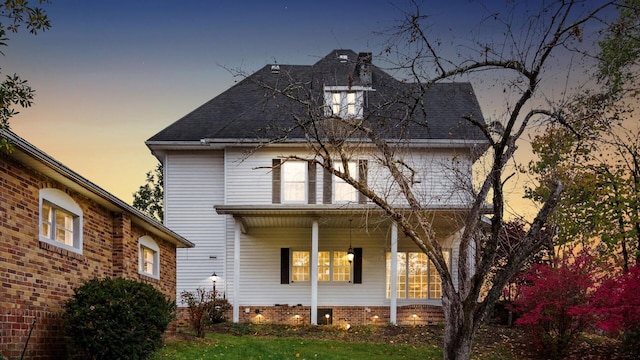 back house at dusk with covered porch