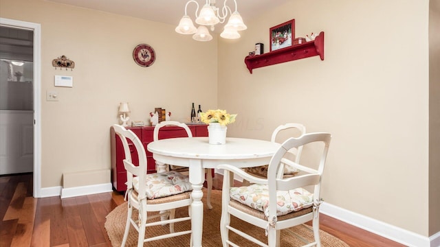 dining room with dark hardwood / wood-style flooring and a notable chandelier