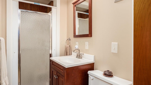 bathroom with vanity, a shower with shower door, and toilet