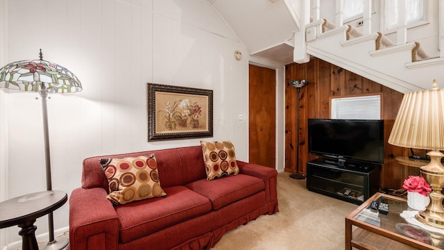 living room featuring wood walls, light carpet, and vaulted ceiling