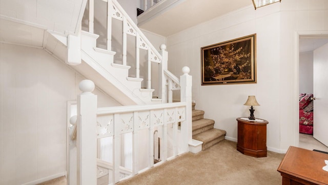 staircase with carpet flooring and ornamental molding