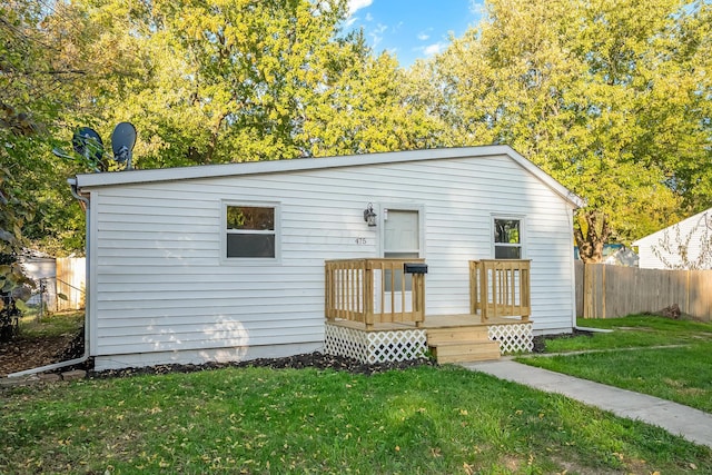 view of front of property with a front yard and a deck