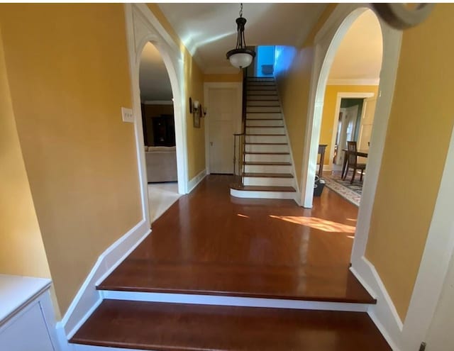 stairway with hardwood / wood-style flooring and crown molding