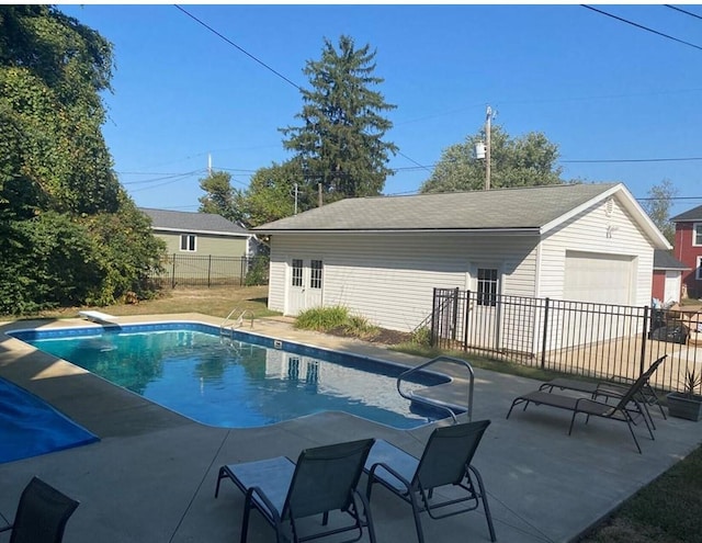 view of swimming pool featuring a diving board and a patio area