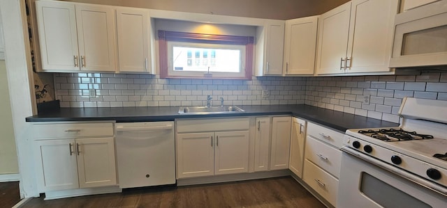 kitchen featuring white cabinets, a sink, dark wood finished floors, dark countertops, and white appliances