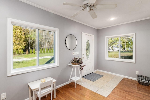 foyer with light hardwood / wood-style floors, ceiling fan, and ornamental molding