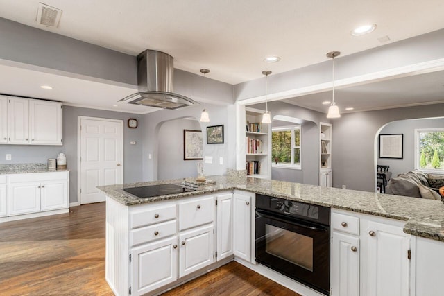 kitchen with wall chimney range hood, white cabinets, kitchen peninsula, and black appliances