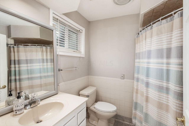 bathroom with walk in shower, vanity, tile walls, tile patterned flooring, and toilet