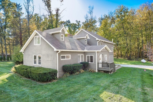 view of front of property with a deck and a front lawn