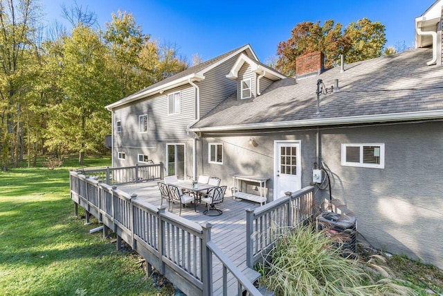 back of property with a lawn and a wooden deck