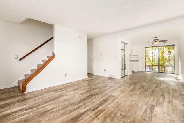 unfurnished living room featuring a textured ceiling, light hardwood / wood-style flooring, and ceiling fan