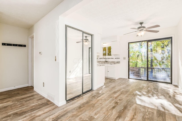 spare room with ceiling fan, a textured ceiling, and light hardwood / wood-style flooring