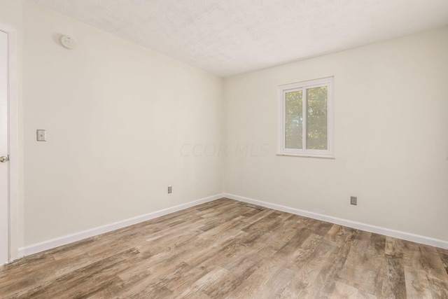 spare room with hardwood / wood-style floors and a textured ceiling