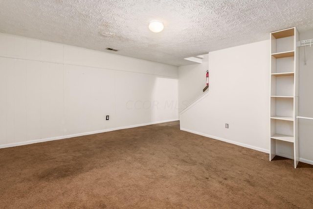 basement with dark carpet and a textured ceiling