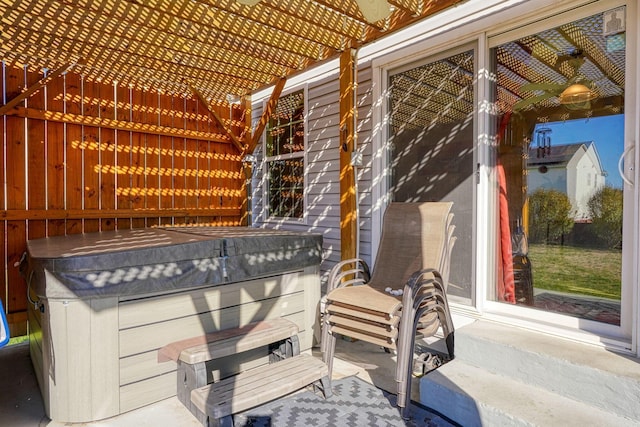 view of patio / terrace featuring a pergola, ceiling fan, and a hot tub