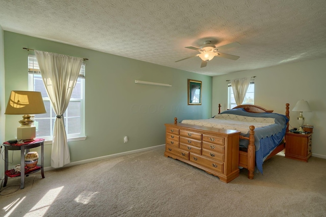 bedroom with ceiling fan, light carpet, and a textured ceiling