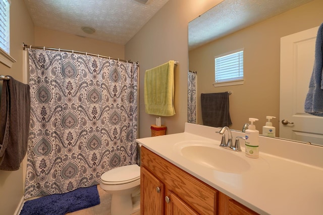 bathroom with tile patterned floors, vanity, toilet, and a textured ceiling