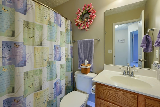 bathroom with vanity, toilet, a textured ceiling, and walk in shower