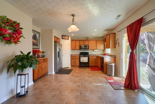 kitchen featuring hanging light fixtures, light tile patterned floors, black appliances, and a textured ceiling