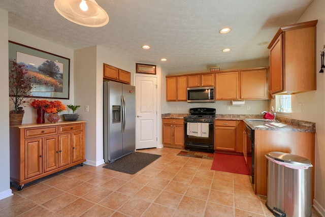 kitchen with black appliances, light tile patterned flooring, sink, and a textured ceiling