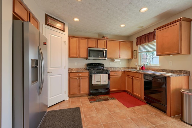 kitchen featuring light tile patterned flooring, a textured ceiling, stone countertops, and black appliances