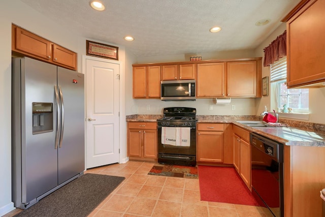 kitchen featuring a textured ceiling, sink, light tile patterned floors, and black appliances