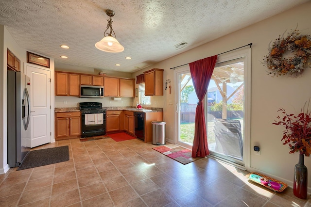 kitchen featuring black appliances, sink, hanging light fixtures, and a textured ceiling