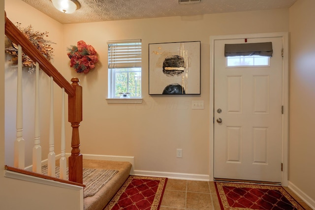 foyer featuring tile patterned flooring and a textured ceiling