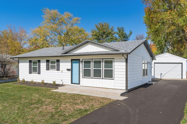 view of front of property featuring an outbuilding, a front yard, and a garage