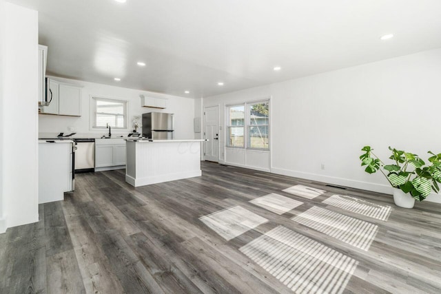 kitchen featuring sink, a kitchen island, hardwood / wood-style floors, white cabinets, and appliances with stainless steel finishes