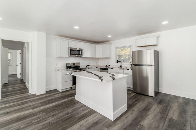 kitchen featuring a center island, white cabinets, sink, dark hardwood / wood-style floors, and stainless steel appliances