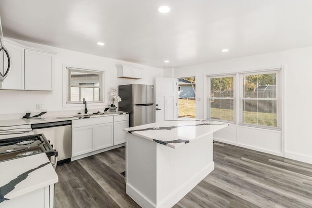 kitchen featuring appliances with stainless steel finishes, dark hardwood / wood-style flooring, white cabinetry, and sink