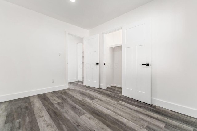 unfurnished bedroom with a closet and dark hardwood / wood-style floors