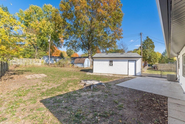 view of yard with a patio, central AC unit, and an outdoor structure