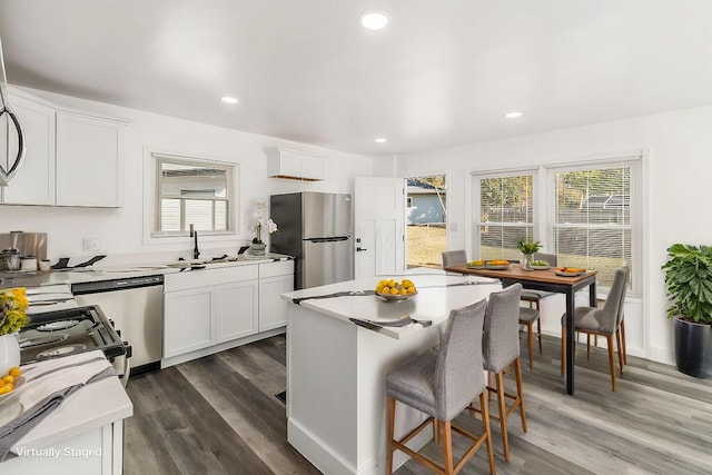 kitchen featuring white cabinets, stainless steel appliances, and plenty of natural light