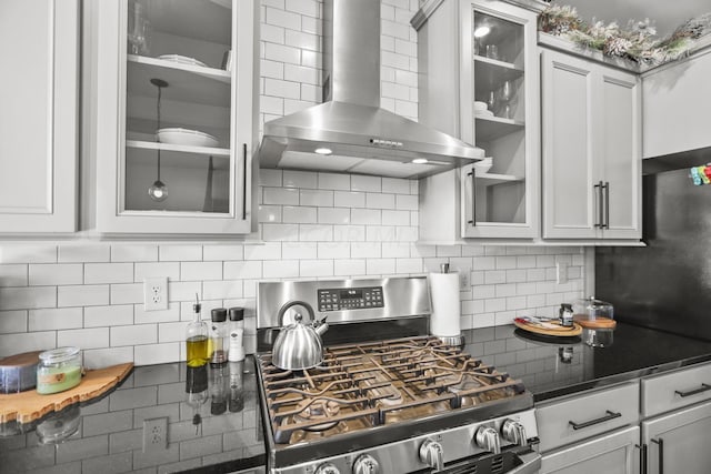 kitchen featuring tasteful backsplash, wall chimney range hood, and stainless steel range with gas stovetop