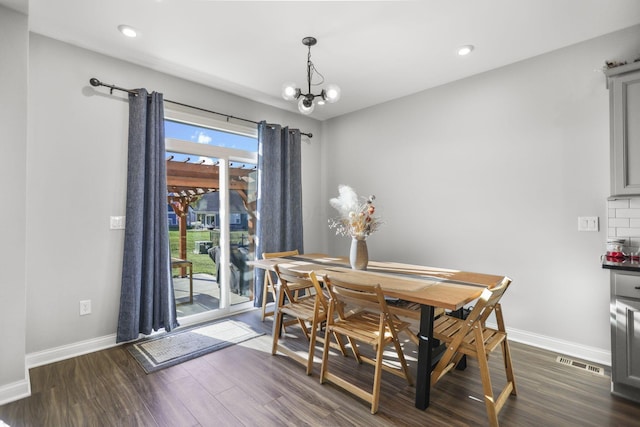 dining area featuring a chandelier and dark wood-type flooring