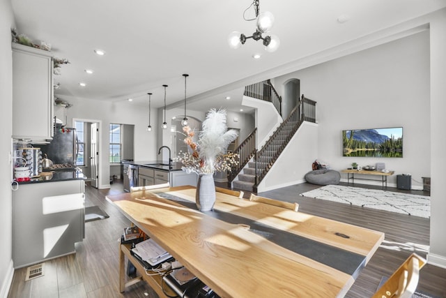 dining room with a chandelier, sink, and dark wood-type flooring