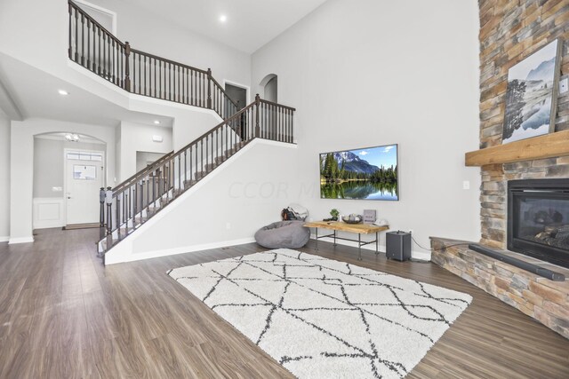 living room with a fireplace, a high ceiling, and dark hardwood / wood-style floors