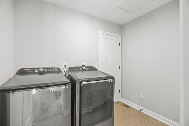 clothes washing area with washing machine and dryer