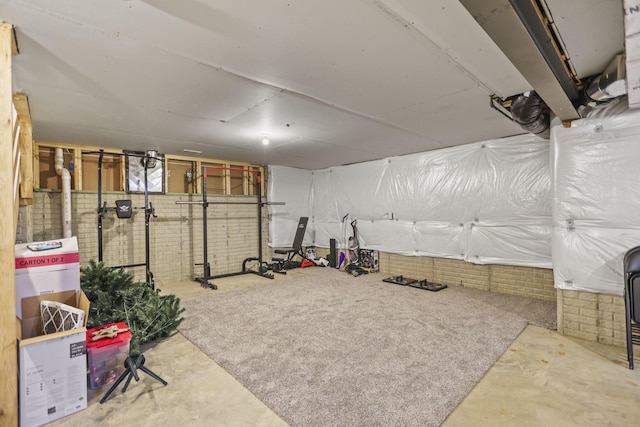 workout room featuring brick wall